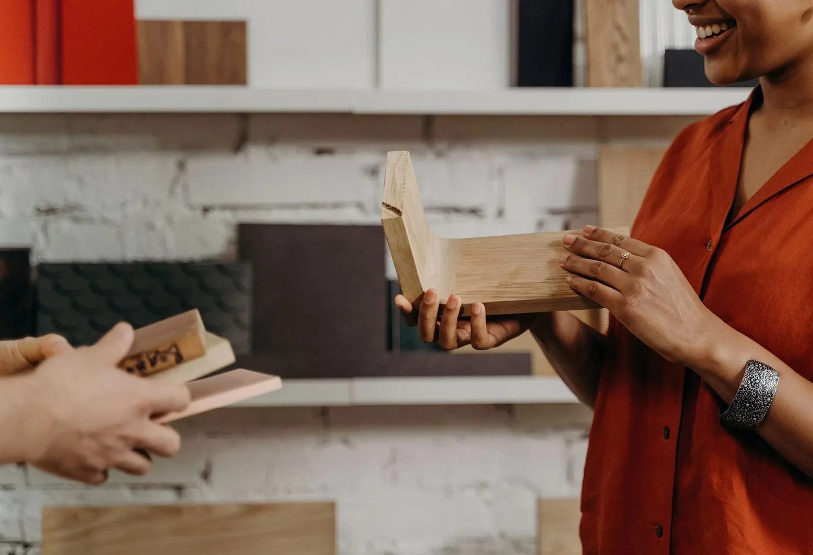 Two people discussing wooden samples in a design studio