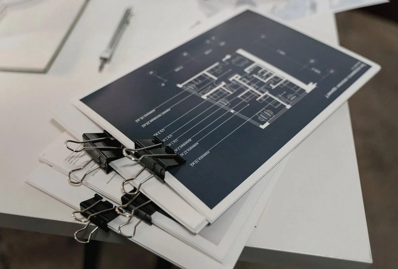 Architectural drawings clipped together on a desk