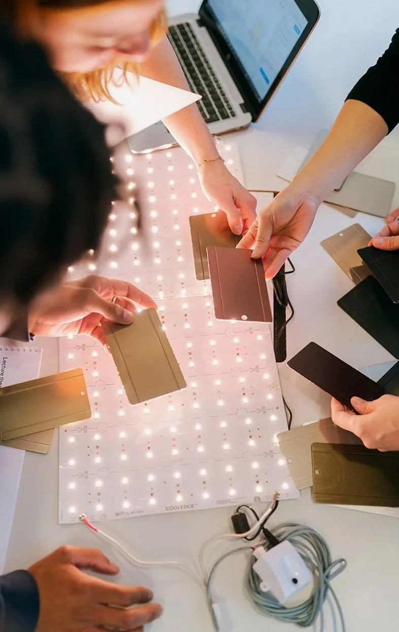 Hands arranging colour and material samples on a light table